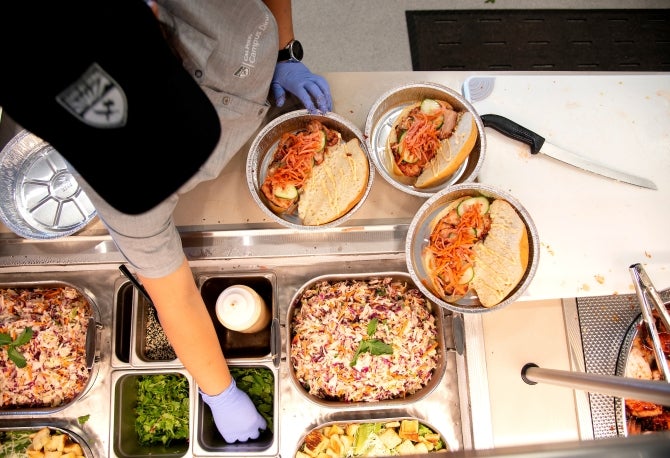 A Cal Poly Campus Dining worker completes to-go meals at Streats