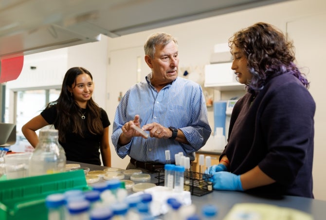 aul Cano, a Cal Poly professor emeritus in biological sciences, meets with students in a university lab