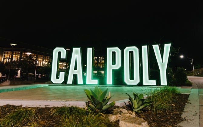 8-foot-tall letters spell out Cal Poly near the University Union  photographed at night 