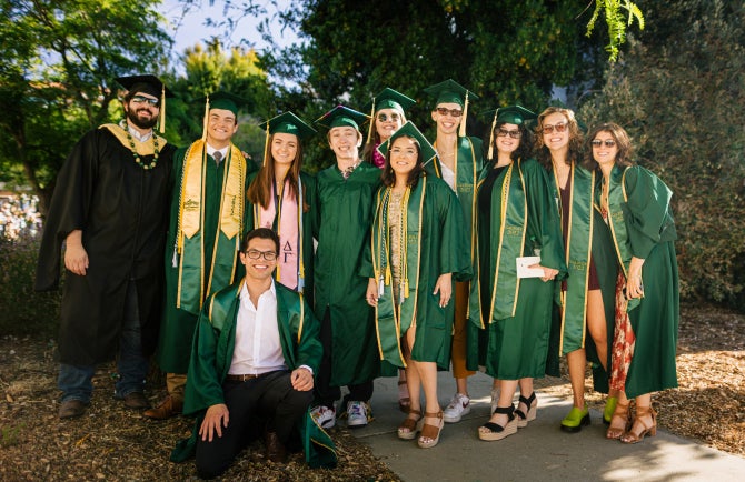 Graduates in regalia stand for a photo before the 2022 commencement