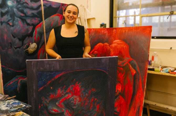 Liliana Monge with several of her paintings
