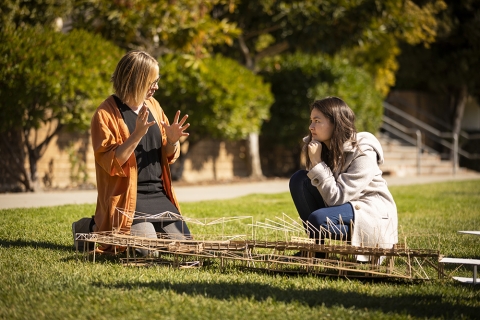 Faculty and student observe student's model on Dexter Lawn during a class presentation