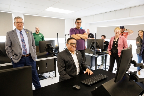 Congressman Carbajal and university leaders and other representatives in a computer room at the air hanger