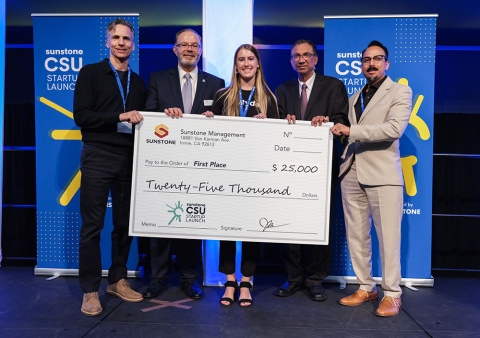 Emily Gavrilenkohholds a 5-foot-long check representing the $25,000 her business, Ryde, won during the Sunstone CSU Startup Launch Competition 