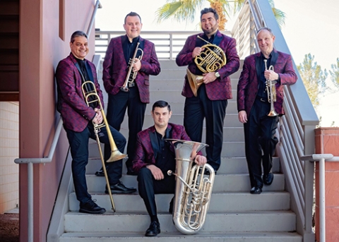The five members of Boston Brass stand on an outdoor stairway with their instruments