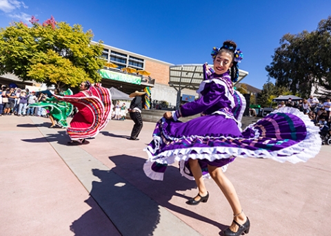 A crowd of campus community members gather outside of Cal Poly’s University Union Plaza to enjoy a group of Ballet Folklorico dancers