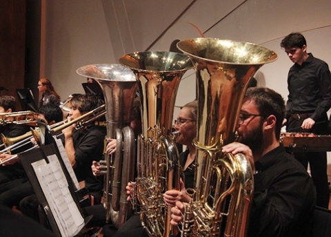 The horn section of the Cal Poly orchestra performs on stage