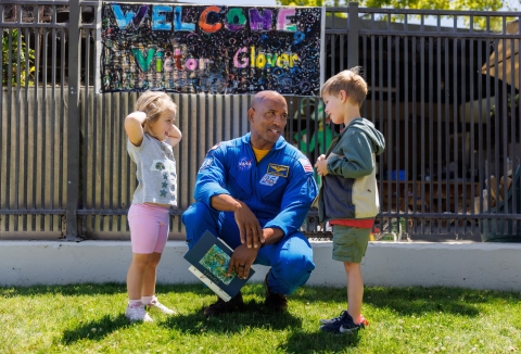 NASA astronaut and Cal Poly Alumnus Victor Glover speaks with two young children outside the Cal Poly Preschool Learning Laboratory.
