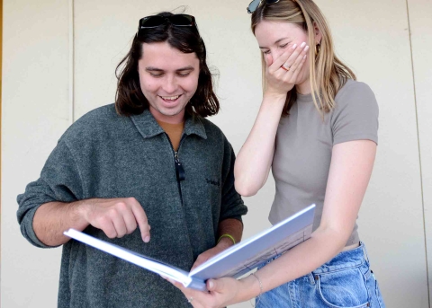 Yearbook editors Christian Gibson and Hannah Scroggins share a laugh while examining the yearbook