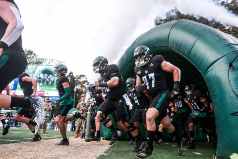 Connor Heffler (No. 47) charges onto the field through an inflatable tunnel before a Cal Poly Mustangs football game.