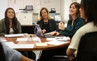 Lisa Sperow meets with her student leadership team around a round table at the Low Income Taxpayer Clinic