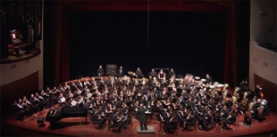 Cal Poly Wind Bands including members of the Alumni Symphonic Band  on stage at the Performing Arts Center