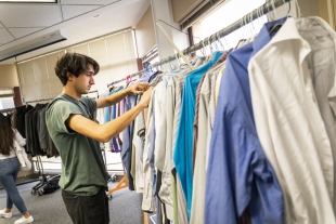 A student looks through dress shirts at Cal Poly Career Services's Professional Clothing Closet