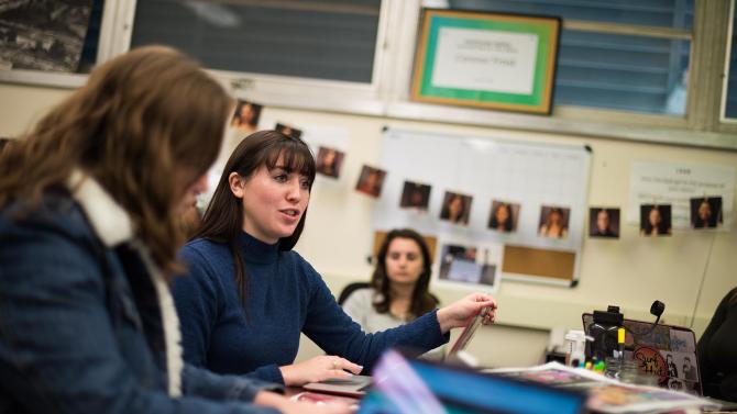 Students have a discussion in a newsroom