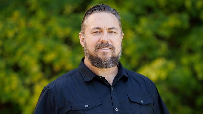 A portrait of Professor Michael Latner against Cal Poly foliage