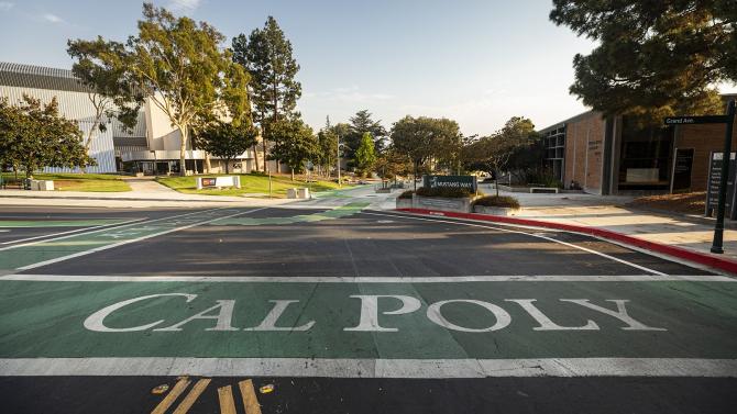 The Cal Poly name painted in a crosswalk on Mustang Way, facing west