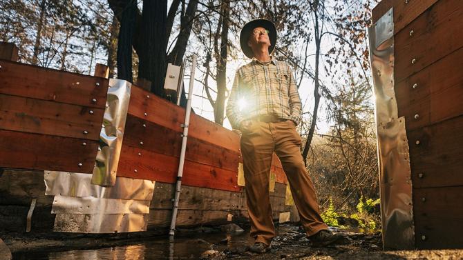 Staff member at Swanton Ranch with sun shining behind him and the trees