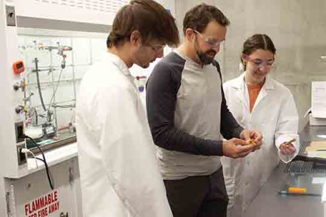 Cal Poly chemistry Professor Phil Costanzo with two students work in a lab on the debondable glue